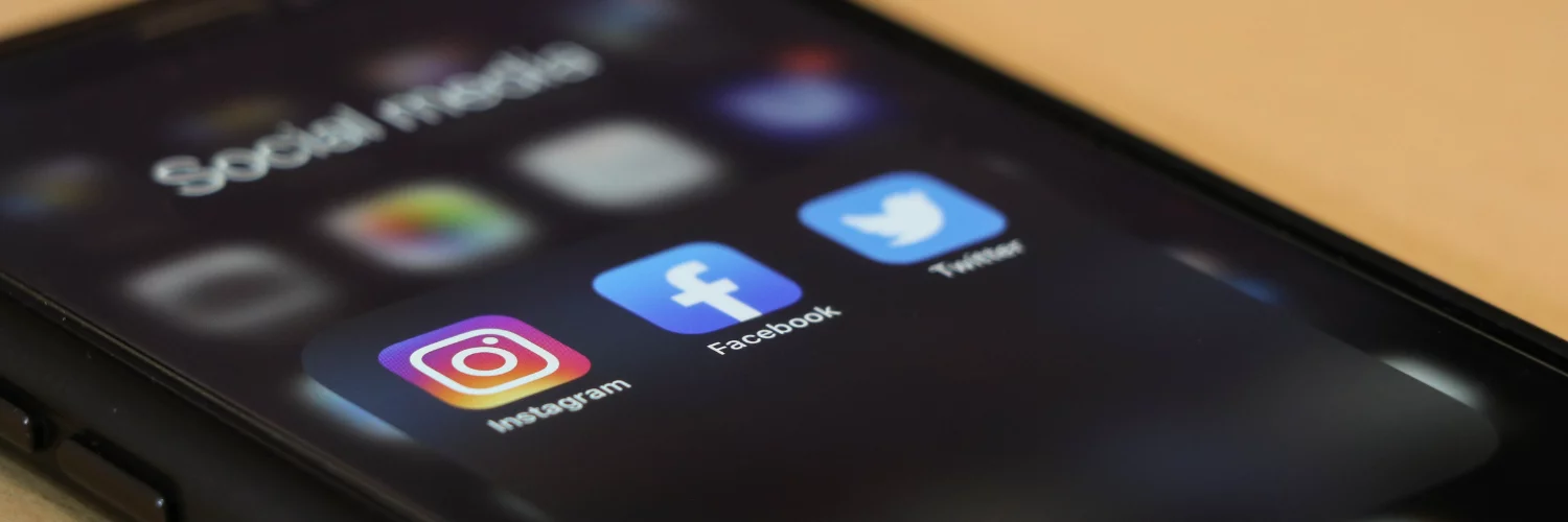 Picture of a phone displaying instagram, facebook and twitter social media apps